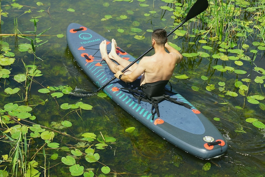 Man paddles a kayak in the water.